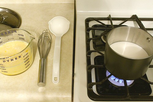 Ingredients for homemade eggnog. Milk in saucepan.