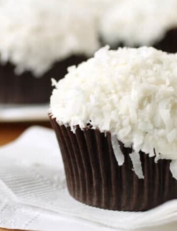 Gluten-free chocolate cupcake with vanilla frosting and shredded coconut.