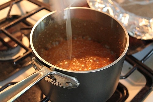 Adding cream to caramel sauce.