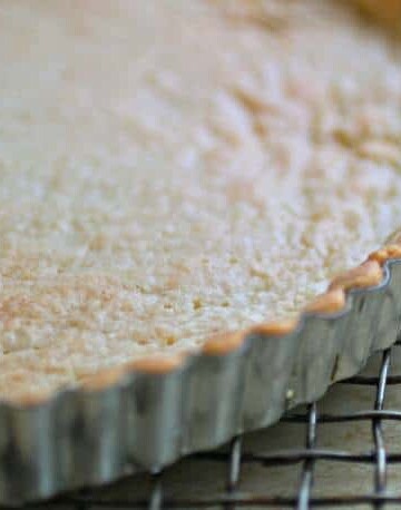 Gluten-free tart shell in pan on cooling rack.