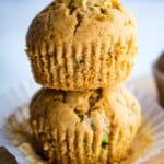 Two gluten-free zucchini muffins stacked on top of each other.