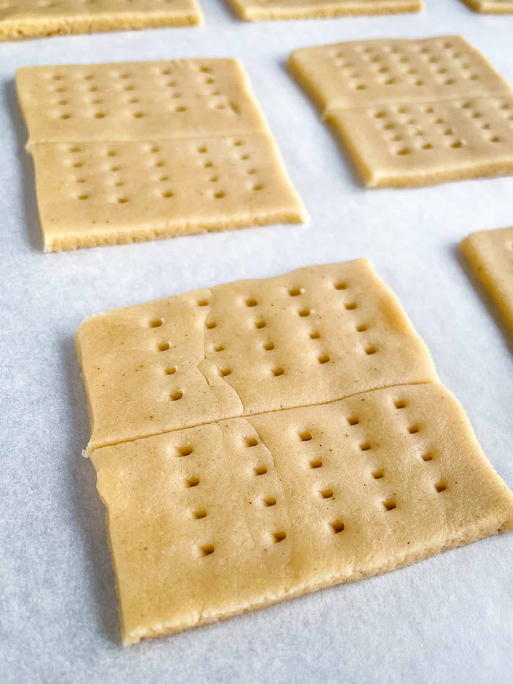 Unbaked gluten-free graham cracker on a baking sheet.