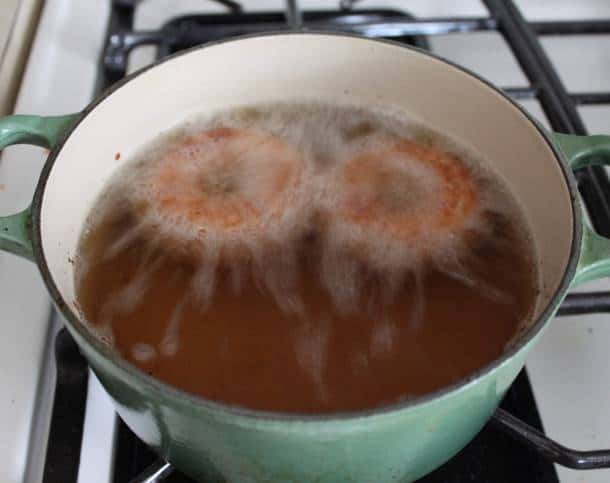 Gluten-free apple cider doughnuts frying.